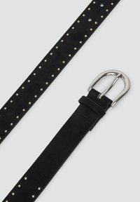 Ceinture en daim noir avec de petites clous en argent le long de sa longueur et une boucle en métal argenté brillant sur un fond gris clair.