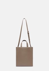 Kwadratowa beżowa skórzana torba z górnymi uchwytami i odczepianym paskiem na ramię. Gładka tekstura, minimalistyczny design, subtelne logo z przodu.