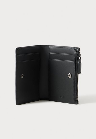 Portefeuille bifold en cuir noir ouvert, montrant plusieurs emplacements pour cartes et un compartiment zippé sur le côté droit sur un fond clair.