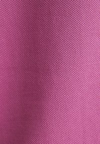 Tissu texturé de couleur rose vif, présentant un motif de tissage serré et une finition lisse, mettant en valeur la consistance de la couleur et la qualité du matériau.