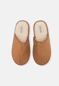 Brown suede slippers with a cozy cream faux fur lining, featuring a slip-on design and contrasting white stitching details.