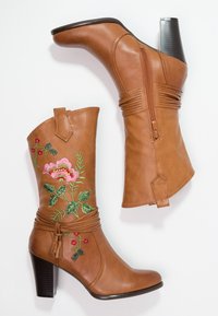 Braune Leder-Stiefel bis zur Knöchel sind mit floralen Stickereien in Pink- und Grüntönen verziert, verfügen über einen Reißverschluss und einen Blockabsatz. Strukturierte Oberfläche.