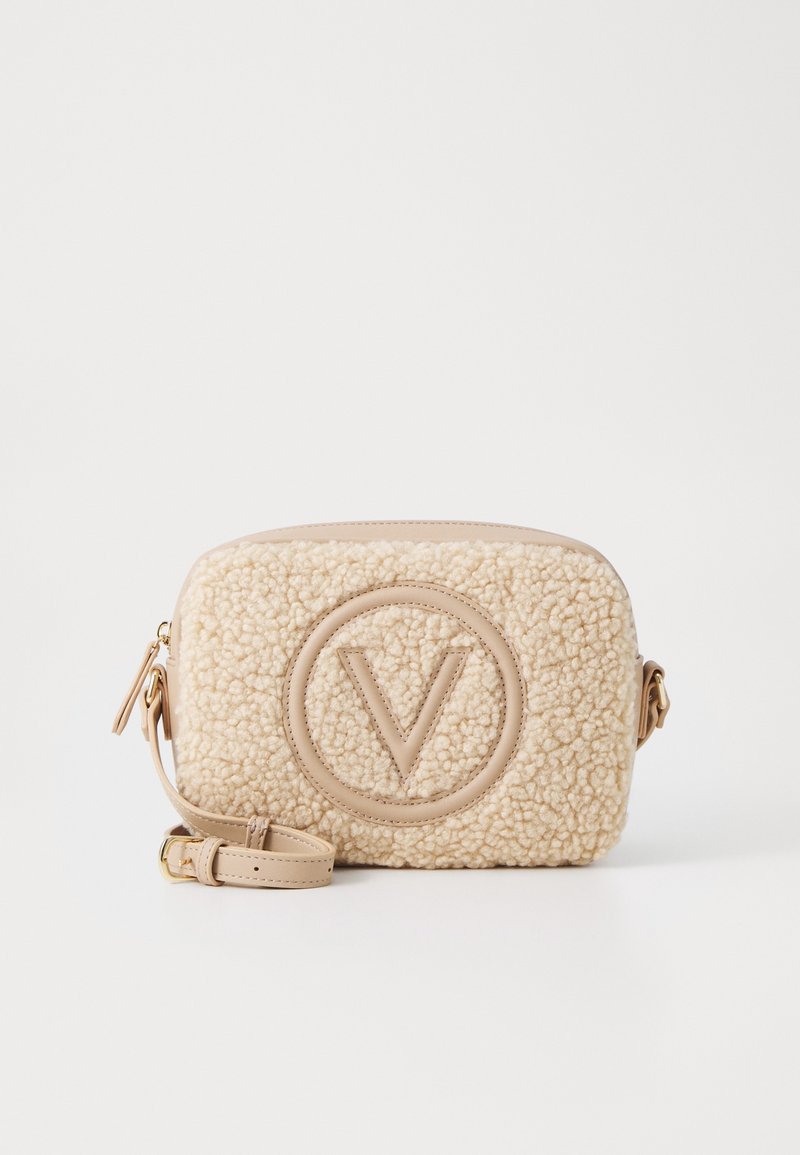 Beige faux shearling crossbody taška s kruhovým logem, koženými akcenty, zipovým uzávěrem a nastavitelným popruhem. Obdélníkový tvar.