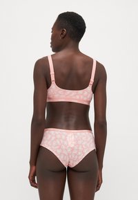 Ροζ σετ εσωρούχων που περιλαμβάνει σουτιέν και αντίστοιχες γυναικείες σλιπ με διακριτικό μοτίβο λεοπάρ. Ρυθμιζόμενες τιράντες και λεπτομέρειες λογοτύπου στη ζώνη.