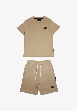 Completo composto da t-shirt beige a maniche corte e pantaloncini con vita elastica, logo nero sul petto e sulla gamba sinistra, coulisse bianca sui pantaloncini.