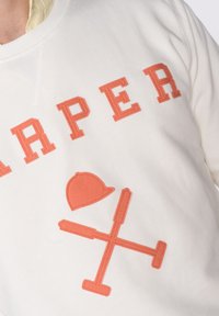 Sudadera blanca con letras coral en negrita que dicen "HARPER" y un gráfico coral con un sombrero y herramientas cruzadas. Material de algodón suave.