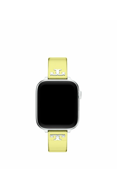 Montre connectée avec un cadre argenté et un écran noir carré, équipée d’un bracelet jaune avec des découpes décoratives métalliques symétriques.