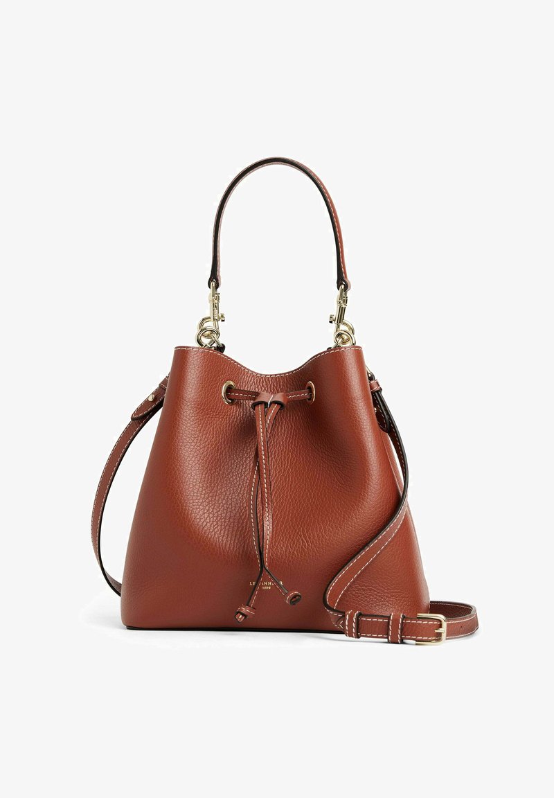 Sac seau en cuir marron avec une finition texturée, fermeture à cordon, et une bandoulière détachable. Accents en métal doré.