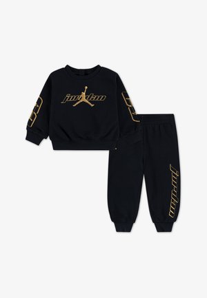 Conjunto de sweatshirt e calças de moletão preto feito de tecido macio. Apresenta texto em dourado e acabamentos de logótipo. A sweatshirt tem um decote redondo e mangas com punhos.