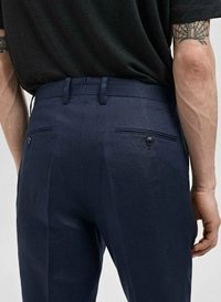 Pantalons marine avec une finition texturée, présentant un devant plat, deux poches arrière avec des boutons, et des passants de ceinture.