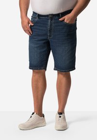 Shorts en denim bleu foncé avec une coupe droite, comportant des poches avant, une fermeture éclair et un ourlet qui se situe au-dessus du genou.