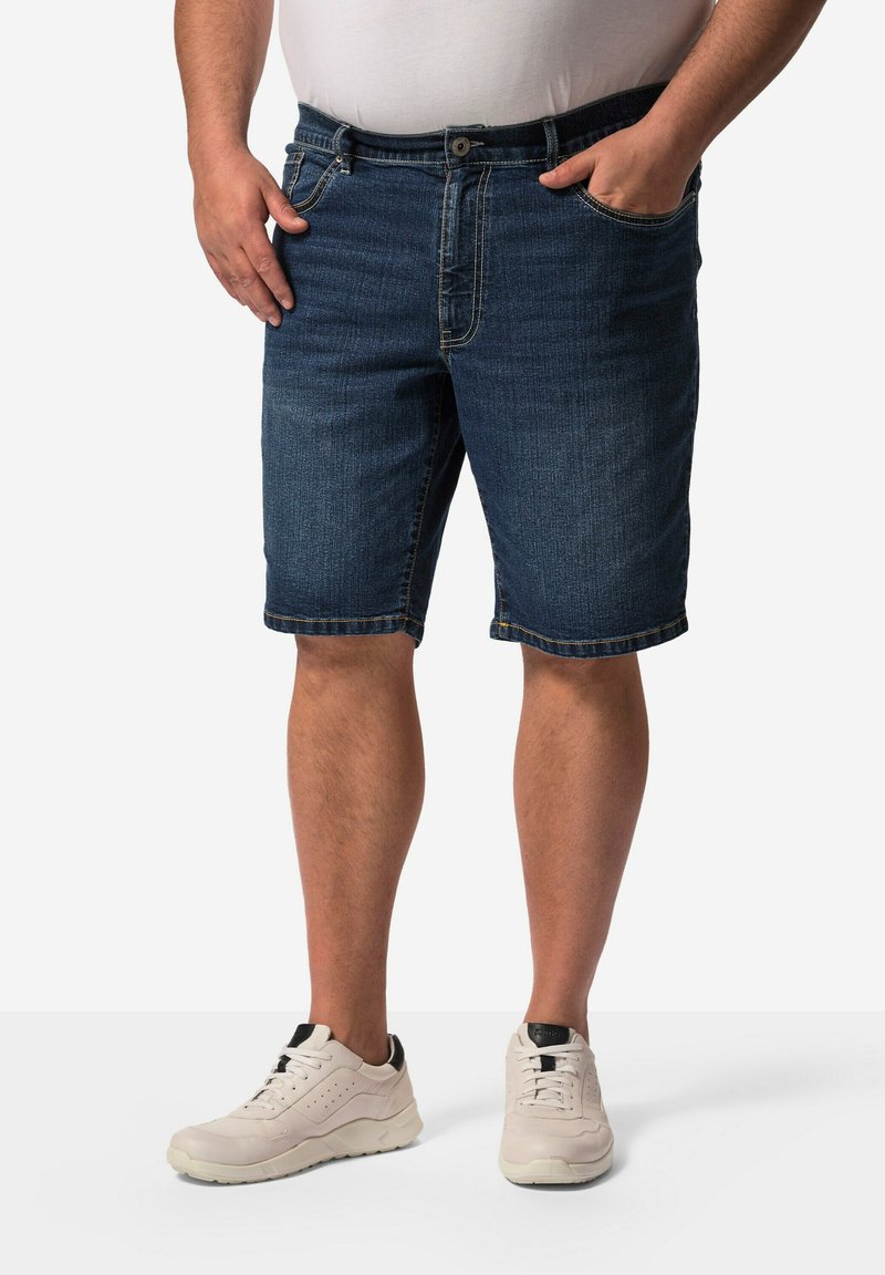 Shorts en denim bleu foncé avec une coupe droite, comportant des poches avant, une fermeture éclair et un ourlet qui se situe au-dessus du genou.