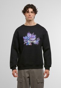 Sort sweatshirt med et multikolor grafisk design med teksten "JUST RHYSE" centralt. Ribbet manchetter og talje, blød tekstur.