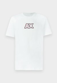 Bijela majica kratkih rukava s okruglim izrezom s velikim "AX" logotipom u crvenoj i crnoj boji, smještenim u sredini prsnog dijela na jednostavnoj pozadini.
