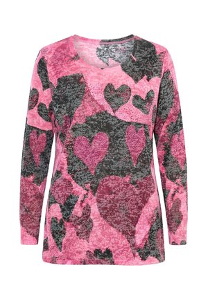 Różowa bluzka z długim rękawem z warstwowym wzorem serc w kolorach różowym, bordowym i ciemnoszarym, z drobnymi zdobieniami na wysokości klatki piersiowej.
