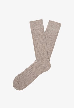 Calzini beige a coste realizzati in un materiale morbido, con tallone e punta rinforzati, una superficie liscia e leggere variazioni di colore.