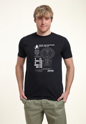 Schwarz T-Shirt mit einem Grafiken des U.S.S. Enterprise und weißen Textdetails. Das Design enthält schematische Elemente und Spezifikationen.
