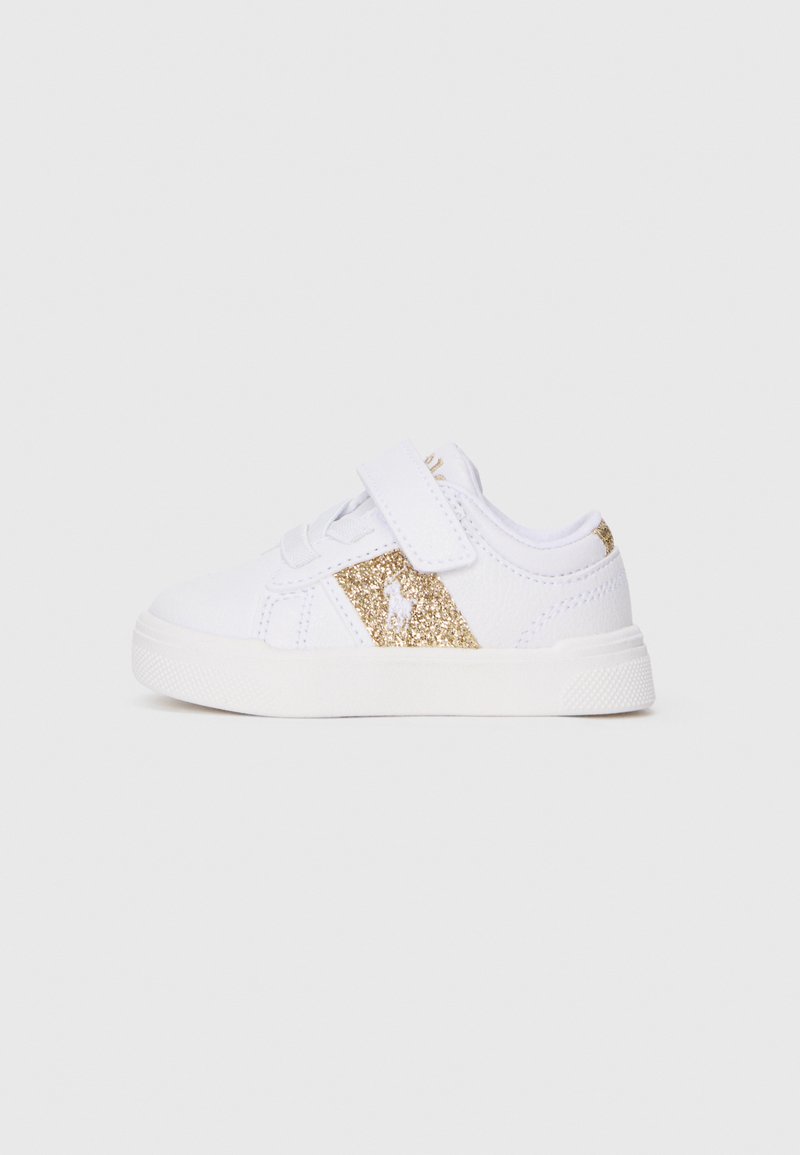 Sapatilha branca com um destaque em glitter dourado de lado, apresentando uma fita de Velcro e sola de borracha branca. Material liso com detalhes em costura.