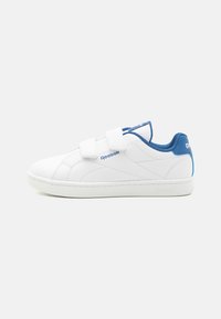 Hvit sneaker med blå detaljer, med en jevn syntetisk overdel, to stropper for lukking, og en teksturert gummisåle. Detaljene inkluderer sømmer og merkevare.
