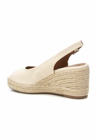 Scarpa con zeppa in tela crema, con punta aperta, design slingback e soletta in juta intrecciata. Fibre naturali testurizzate accentuano la piattaforma.