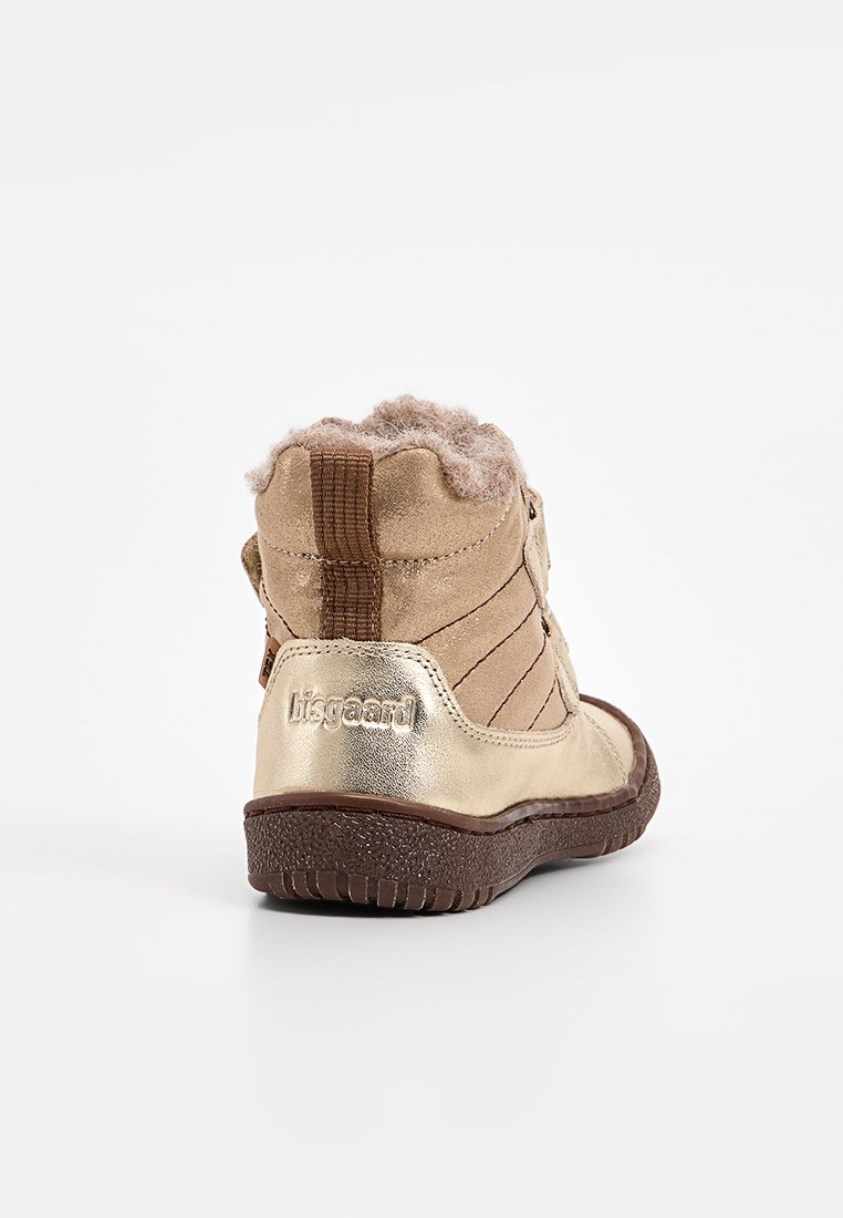 Tan- und metallisch goldene Ankle Boots mit weichem Plüschfutter, seitlichen Streifen und Text auf der Ferse. Runde Zehenpartie und strukturierte Sohle.
