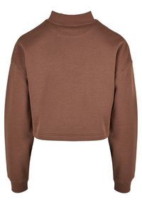 Bruine cropped sweatshirt met een hoge geribbelde kraag en lange mouwen. Gemaakt van zachte stof, met een strak, eenvoudig ontwerp en afgewerkte randen.