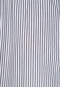 Tessuto bianco con strette strisce verticali blu navy, texture liscia, leggero e traspirante. Presenta un motivo nitido e pulito.