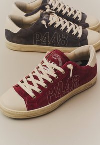 Deux baskets en daim, une bordeaux et une bleu marine foncé, avec des lacets crème, bouts, semelles et "P448" brodés sur les côtés.