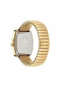 Gul rostfritt stål klocka med fyrkantig urtavla och metallarmband. Har en logotyp på baksidan och en polerad yta.