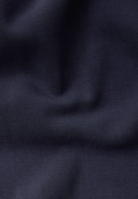 Tessuto blu navy con una superficie liscia e leggermente texture, che presenta pieghe e grinze delicate per un aspetto dinamico.
