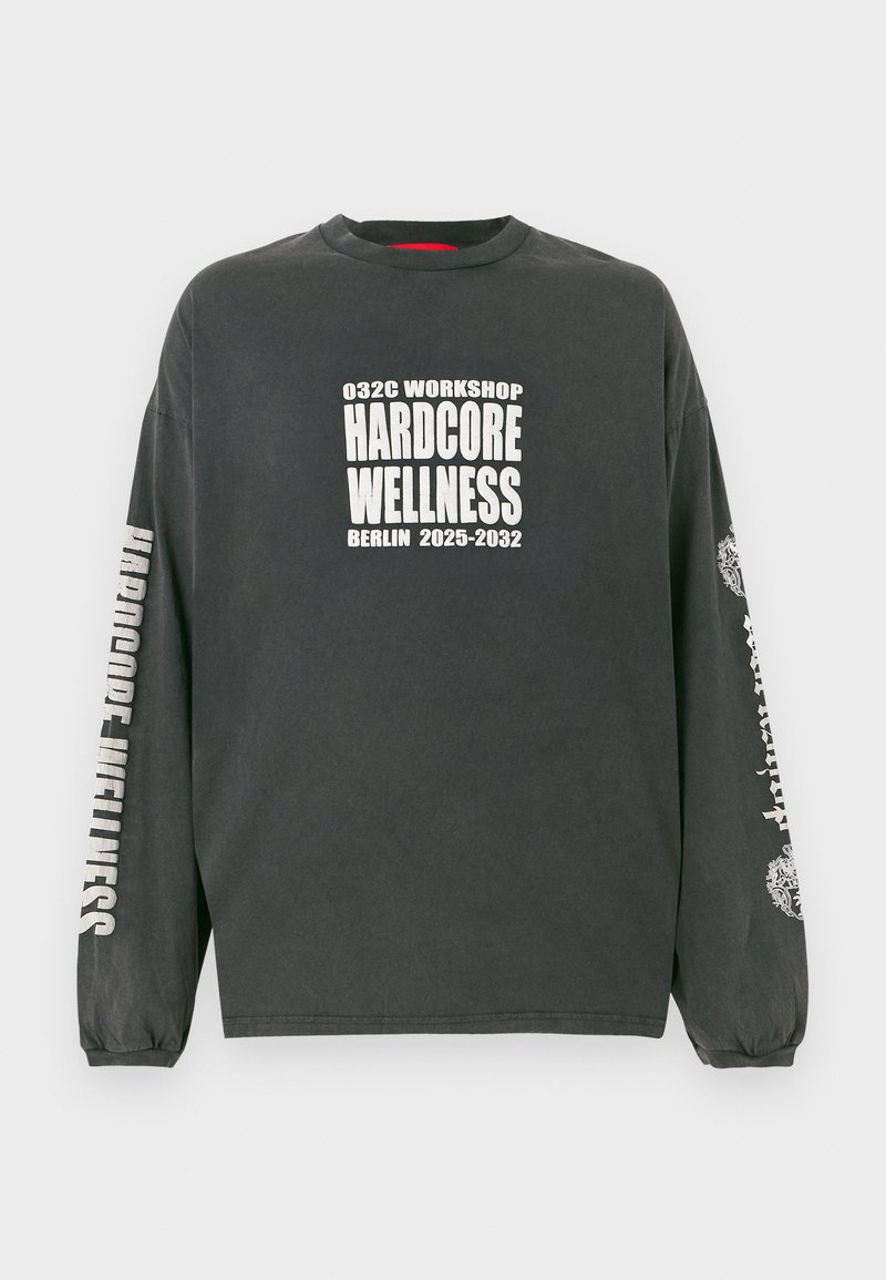 Dunkelgraues Langarmshirt mit weißem Text "032C Workshop Hardcore Wellness Berlin 2025-2032" auf der Vorderseite und den Ärmeln, mit elastischen Bündchen.