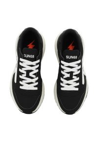 Sneakers neri con tomaia in tessuto, lacci bianchi e suola color crema. Presentano un logo a forma di fulmine e il branding "SUN68" sulla linguetta.