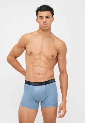 Hellblaue Boxerbriefs mit schwarzem Bund, der das Puma-Logo zeigt. Der Stoff wirkt glatt und elastisch, mit einer enganliegenden Passform.