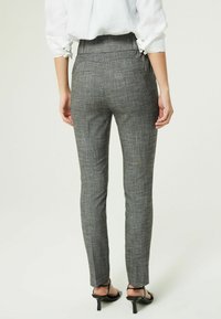 Grå rutede bukser med slim fit, høj talje og en glat tekstur. Har skræddersyede sømme og en ren afslutning ved anklerne.