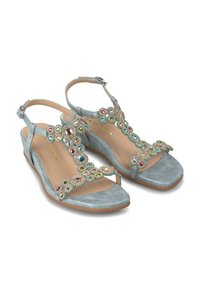 Sandales compensées bleu clair avec une finition texturée, ornées d'ornements en pierres précieuses multicolores sur la sangle supérieure. Sangle de cheville réglable.