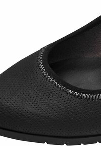 Čierne perforované slip-on topánky s okrúhlou špičkou a kontrastným prešívaným okrajom. Mäkký materiál s flexibilnou gumovou podrážkou.