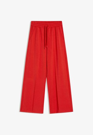 Piros, bőszárú nadrág gumis derékrésszel, húzózsinórral és első zsebekkel, fehér háttéren laposan elrendezve.