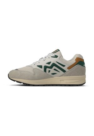 Beige en groene sportsneaker met suède accenten, een patroon aan de zijkant, veterluiting en rubberen zool.