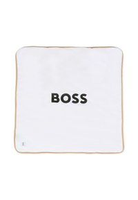 Biały kwadratowy koc z beżowym brzegiem, z wyraźnie wyeksponowanym słowem "BOSS" wytłoczonym dużymi czarnymi literami.
