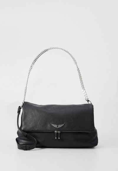 Sac en cuir noir avec une bandoulière en chaîne argentée, logo en métal ailé et fermeture à rabat zippée sur fond blanc uni.
