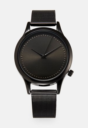 Black analog wristwatch with minimalist dial, no numbers, small dot and triangle markers, and a mesh metal strap showing time 10:09:04.