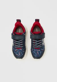 Granatowe tenisówki z tekstylną cholewką w wzory, z czerwonymi i białymi akcentami, gumową podeszwą, metalowymi przelotkami i regulowanym paskiem.