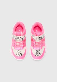 Zapatillas deportivas en rosa y blanco con una parte superior de malla, acentos de piel sintética y un patrón de manchas negras. Presentan cordones y una correa a lo largo del mediopie.