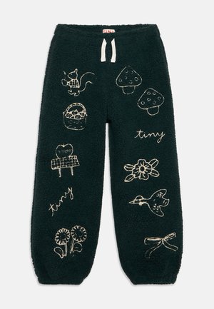 Calças de flanela verde escuro com desenhos bordados em branco de um esquilo, cogumelos, flores, um pássaro, uma cesta e a palavra "tiny".