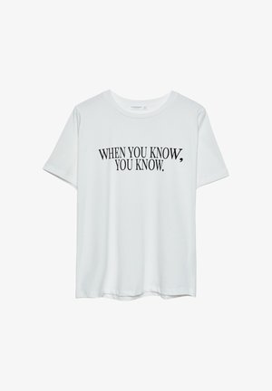 Bijela pamučna majica s kratkim rukavima i okruglim izrezom. Sadrži crni natpis: "KADA ZNAŠ, ZNAŠ." Ispisano podebljano.