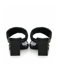 Sandales noires à talons avec de larges talons en bloc rectangulaires et des brides tressées à la cheville. Matériau supérieur lisse avec une finition brillante.