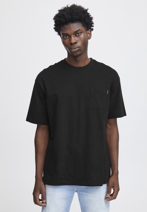 Zwarte katoenen T-shirt met een ronde hals, korte mouwen en een borstzak. De stof heeft een gladde textuur en een relaxte pasvorm.