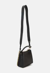 Borsa a tracolla in pelle nera con una forma strutturata, caratterizzata da una finitura testurizzata e con dettagli in metallo dorato lungo la cucitura. Inclusa tracolla regolabile.