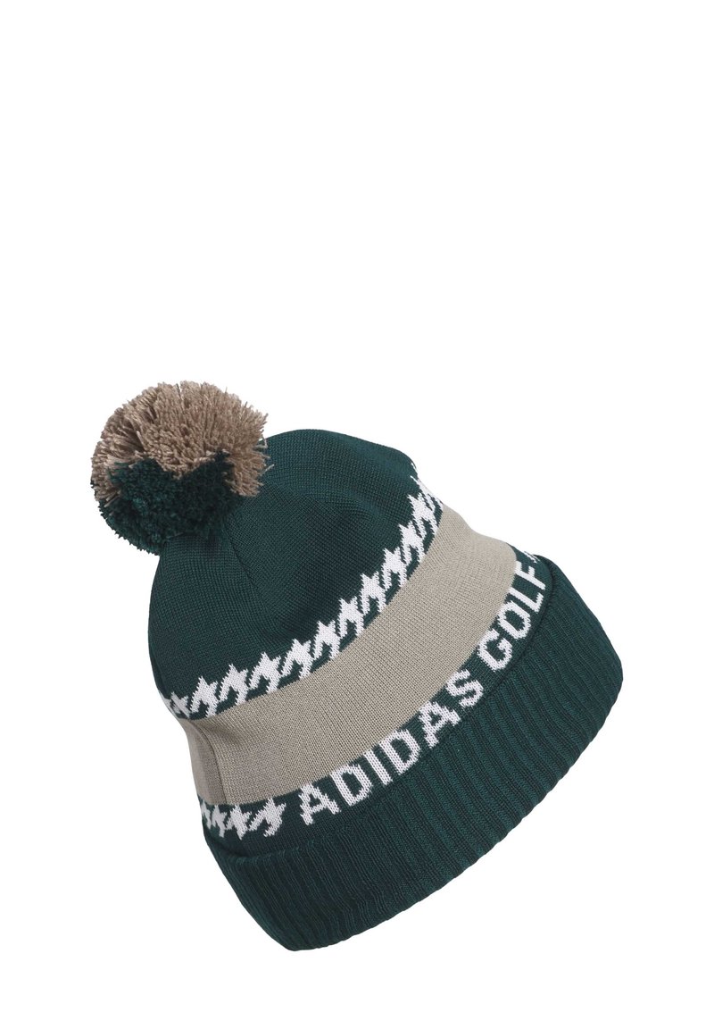 Zielona dzianinowa czapka z kremowym paskiem, białym wzorem zygzaka i brązowym pomponem na górze; ma na sobie biały napis "ADIDAS GOLF".