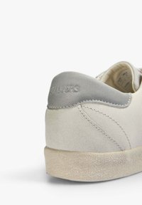 Sneaker grigio chiaro con tomaia in camoscio, suola in gomma testurizzata e copertura del tallone grigia liscia con branding impresso.